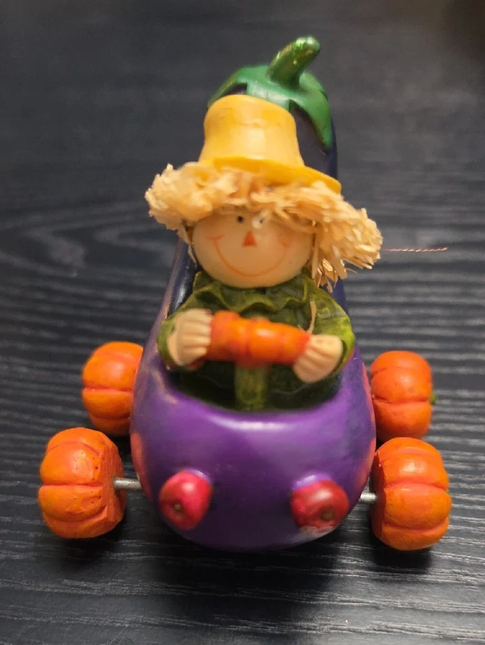 Autumn figurine of a scarecrow in a Eggplant cart